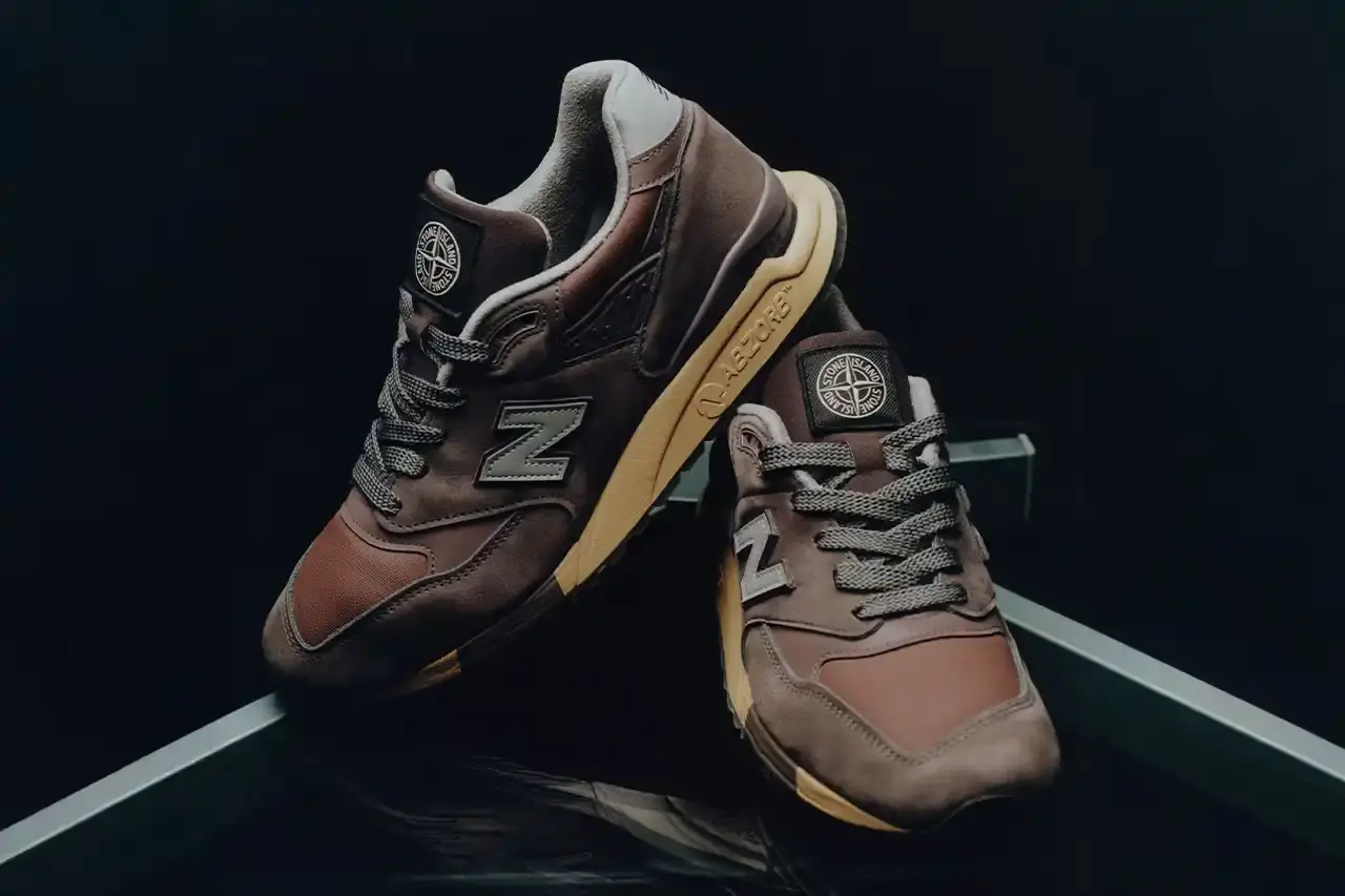 Stone Island/New Balance New Balance 998 sneakers redesigned by Stone Island, featuring polyurethane-coated cotton canvas in mauve, plum, and copper tones with reflective details.
