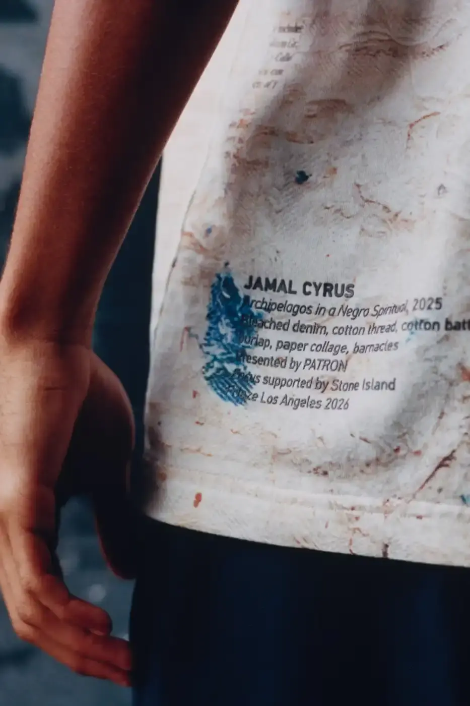 STONE ISLAND JAMAL CYRUS FRIEZE LA 2026 SHIRT A white t-shirt featuring black and grey abstract digital prints inspired by archival documents and historical collage. (image 5 of 6)