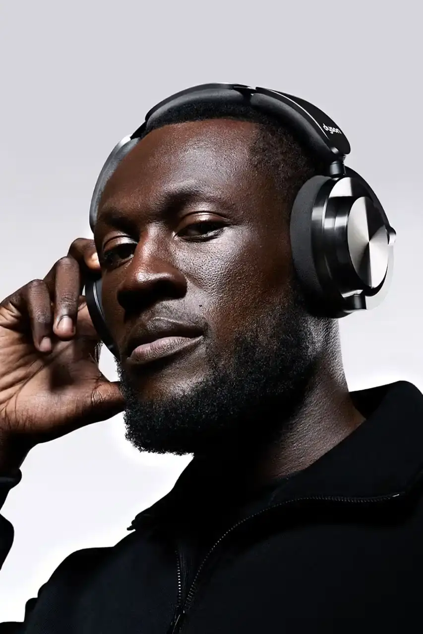 Stormzy wearing black Dyson OnTrac headphones while working in a recording studio