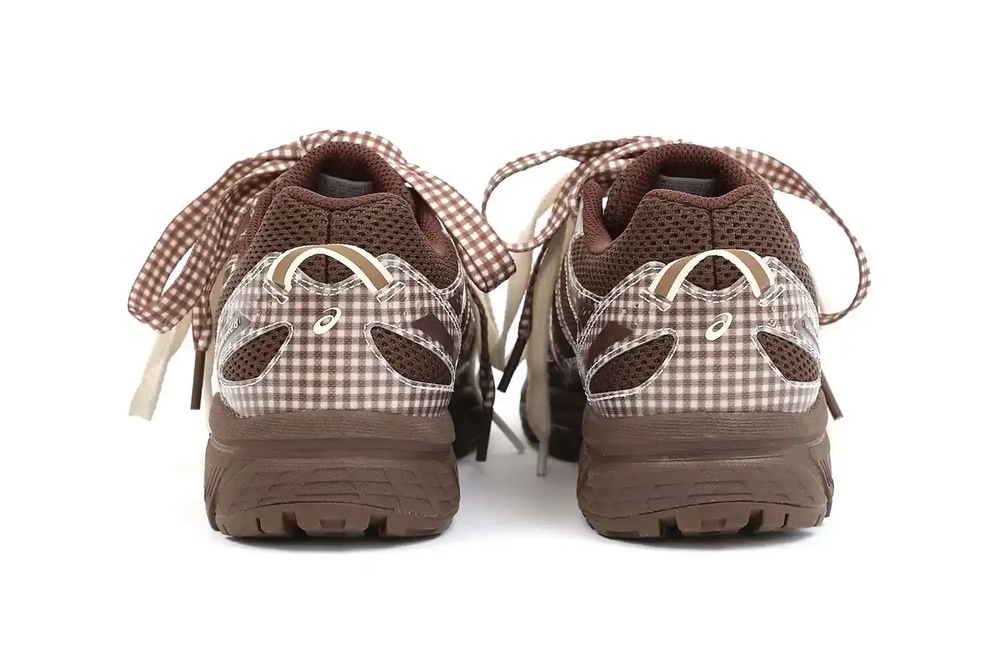 ASICS GEL-VENTURE 6 GETS GINGHAM MAKEOVER FROM STORY MFG. photo of the collaboration between sustainable fashion brand STORY mfg. and ASICS on the GEL-VENTURE 6 sneaker. It details the two gingham colorways ("Reddish Brown" and "Vanilla Violet Quartz"), the unique woven lacing system inspired by Baghdad skaters, and pricing ($133 USD). The article also describes the two-day launch event at The Truman Brewery in London on April 18-19, where visitors can contribute embroidery to a community art project while enjoying refreshments. The article provides purchase information and explains STORY mfg.'s sustainable fashion background. (image 8 of 14)
