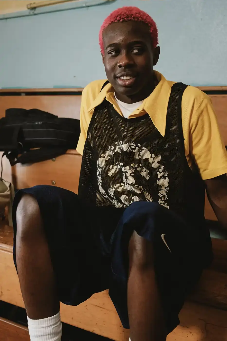 Stüssy/Denim Tears A display of Stüssy x Denim Tears' school-inspired collection, showing oxford shirts, blazers, and chinos arranged on a neutral background. The pieces feature co-branded designs and Pan-African American flag motifs. (image 4 of 11)