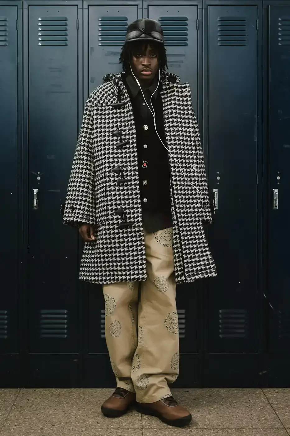 Stüssy/Denim Tears A display of Stüssy x Denim Tears' school-inspired collection, showing oxford shirts, blazers, and chinos arranged on a neutral background. The pieces feature co-branded designs and Pan-African American flag motifs. (image 2 of 11)