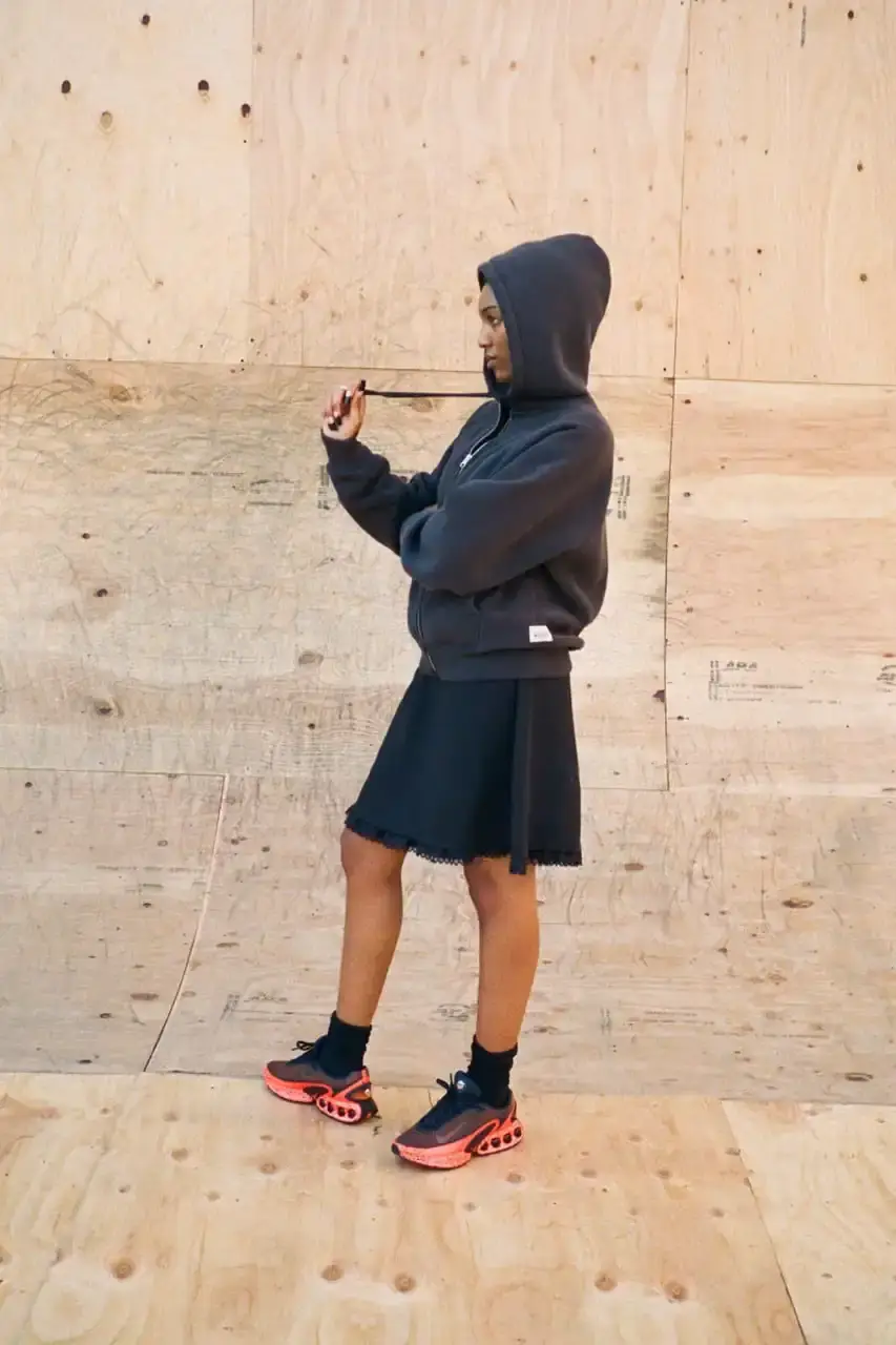 Antosh Cimoszko Stüssy Spring 2025 collection lookbook featuring an urban model wearing an oversized camouflage jacket, baggy denim trousers, and wide-cut shorts in muted green and blue tones. (image 12 of 26)