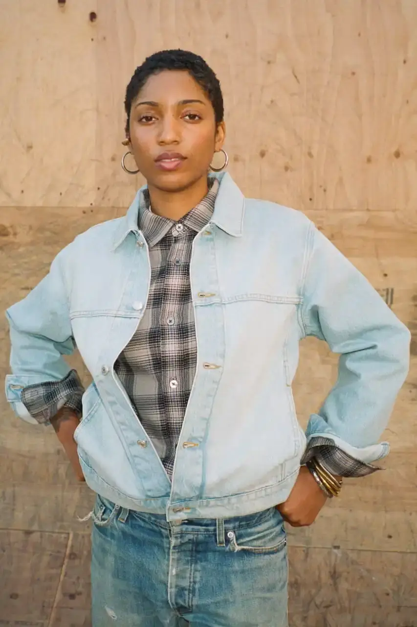 Antosh Cimoszko Stüssy Spring 2025 collection lookbook featuring an urban model wearing an oversized camouflage jacket, baggy denim trousers, and wide-cut shorts in muted green and blue tones. (image 10 of 26)
