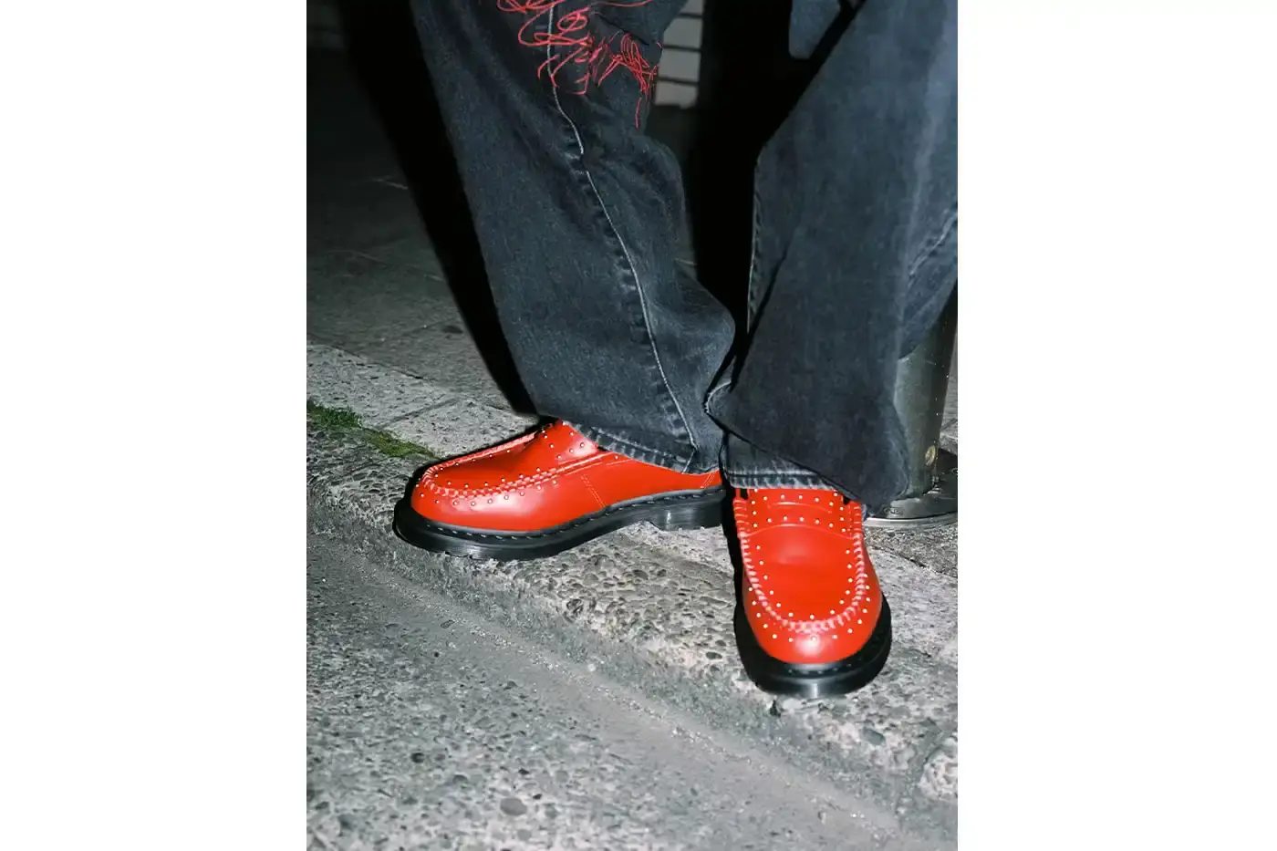 SUPREME TEAMS WITH DR. MARTENS ON EXCLUSIVE PENTON LOAFERS image of the Spring 2025 collaboration between Supreme and Dr. Martens featuring Studded Penton Loafers. The piece describes the three colorways (black, red, and green), the distinctive metal stud detailing around the shoes, co-branded footbeds, and AirWair® cushion soles. Release dates are May 22 for global markets and May 24 for Asian markets, available through Supreme's website and physical stores. The article also briefly mentions Supreme's recent footwear collaborations with Vans and Nike. (image 5 of 5)
