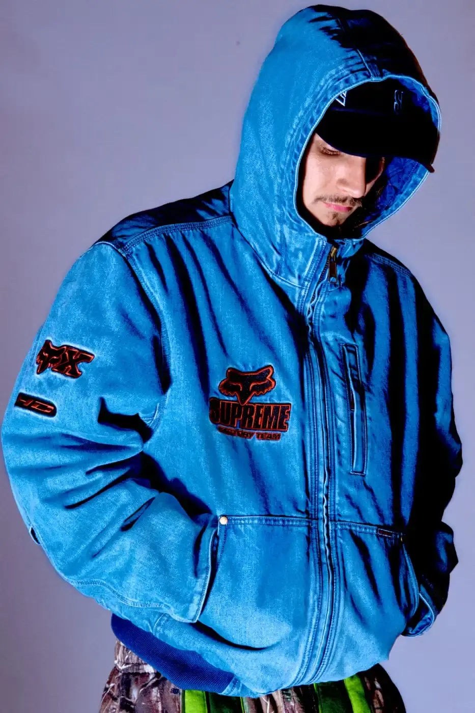 SUPREME X FOX RACING FALL 2025 DROP Supreme collaborates with Fox Racing on a Fall 2025 collection that includes motorsport gear and apparel, featuring tribute pieces to DMX with racing jerseys, helmets, and protective gear in gray camo print with red accents. (image 24 of 26)
