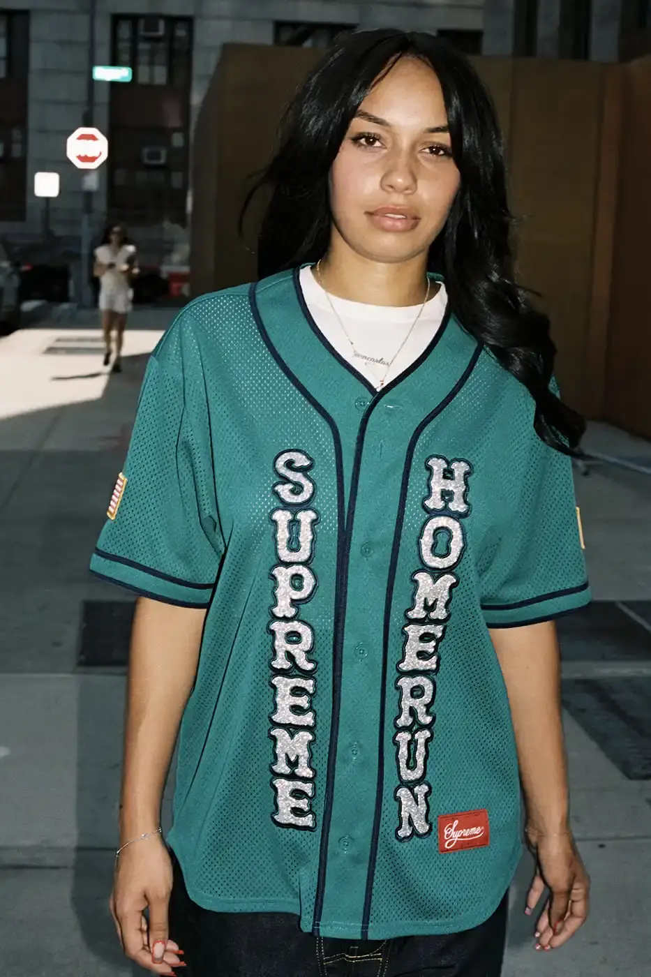 SUPREME PARTNERS WITH HOMERUN FOR BASEBALL-INSPIRED COLLECTION image of the Spring 2025 collaboration between Supreme and Homerun, a brand based in both New York City and Tokyo. The collection features baseball-inspired apparel including varsity jackets in silver and black, baseball jerseys in teal, navy, and pinstriped designs, plus hooded sweatshirts, t-shirts, and New Era caps. All items display co-branding with Homerun's cartoon graphics and "Non Stop" motto. The collection launches May 15 globally and May 17 in Asia through Supreme's website and stores. (image 9 of 14)