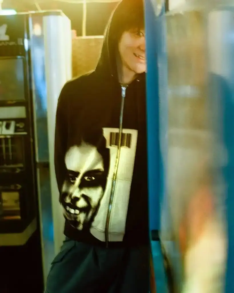 Supreme Supreme x Aphex Twin capsule collection lookbook image showing clothing items featuring iconic Aphex Twin album artwork and logos, including the distinctive logo designed by Paul Nicholson. (image 6 of 10)