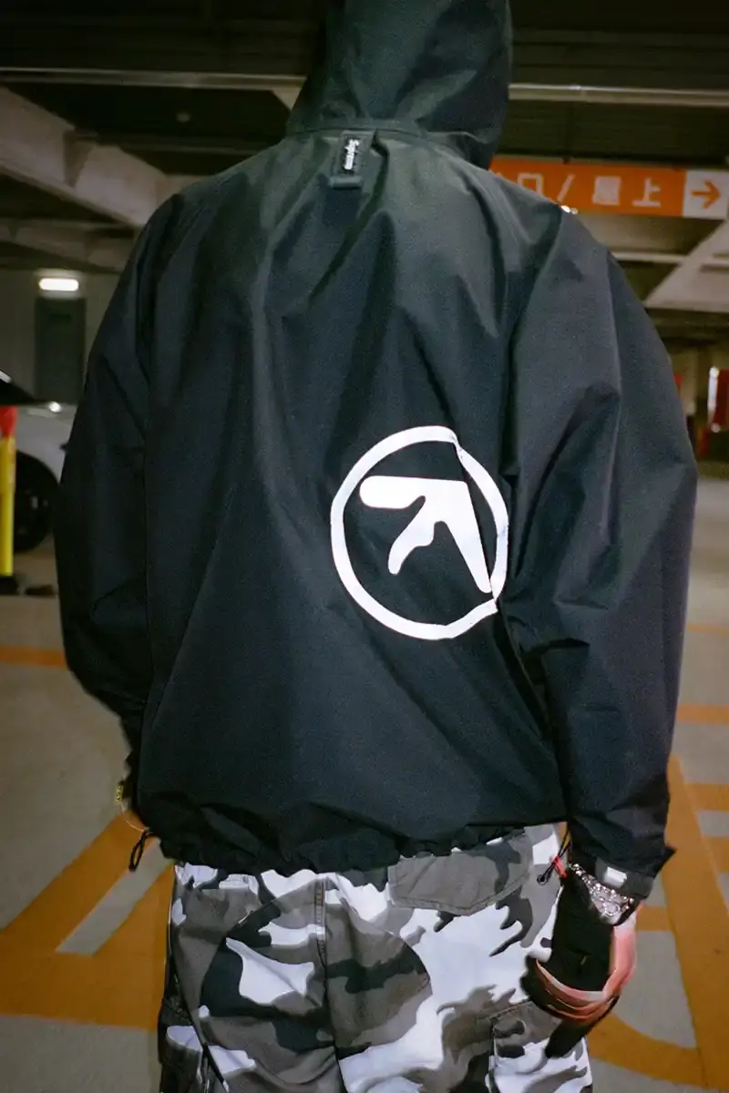Supreme Supreme x Aphex Twin capsule collection lookbook image showing clothing items featuring iconic Aphex Twin album artwork and logos, including the distinctive logo designed by Paul Nicholson. (image 2 of 10)