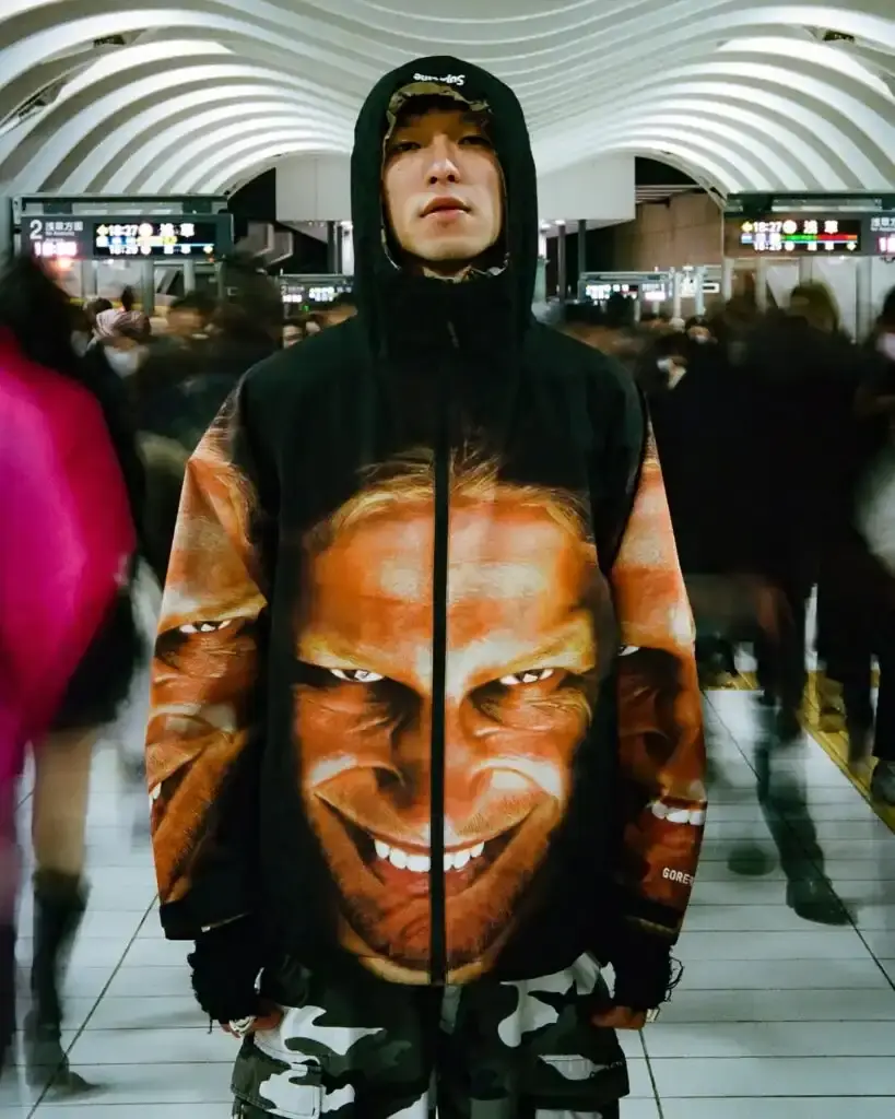 Supreme Supreme x Aphex Twin capsule collection lookbook image showing clothing items featuring iconic Aphex Twin album artwork and logos, including the distinctive logo designed by Paul Nicholson. (image 3 of 10)