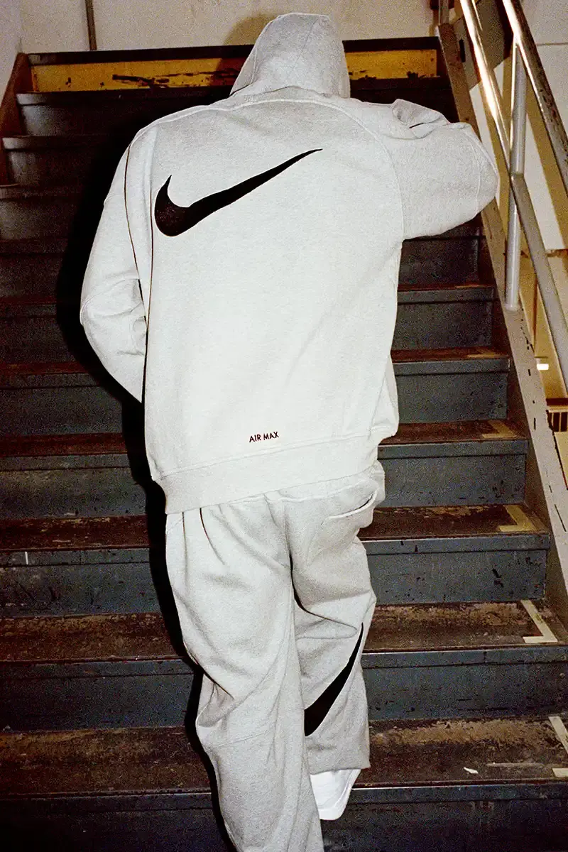 Supreme/Nike Supreme x Nike Spring 2025 Collection featuring black and white Leather Varsity Jackets, purple, yellow and black Track Suits, striped Rugby shirts, Sweater Vests, Hooded Sweatshirts, and accessories including Running Hats and Leather Shoulder Bags. (image 7 of 22)
