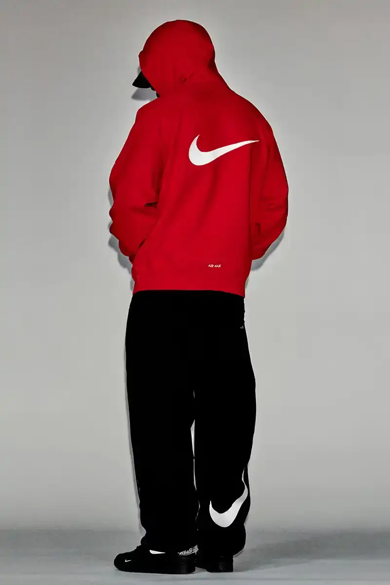 Supreme/Nike Supreme x Nike Spring 2025 Collection featuring black and white Leather Varsity Jackets, purple, yellow and black Track Suits, striped Rugby shirts, Sweater Vests, Hooded Sweatshirts, and accessories including Running Hats and Leather Shoulder Bags. (image 5 of 22)