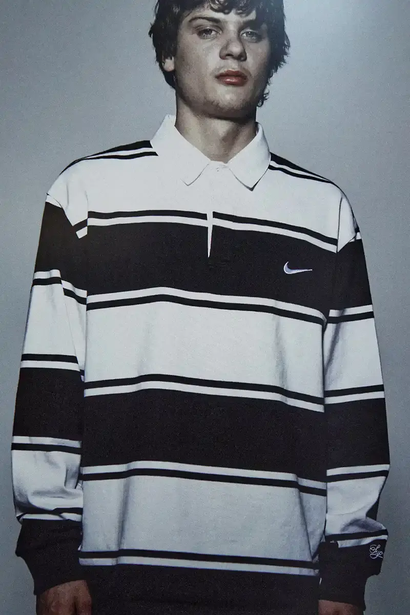 Supreme/Nike Supreme x Nike Spring 2025 Collection featuring black and white Leather Varsity Jackets, purple, yellow and black Track Suits, striped Rugby shirts, Sweater Vests, Hooded Sweatshirts, and accessories including Running Hats and Leather Shoulder Bags. (image 11 of 22)