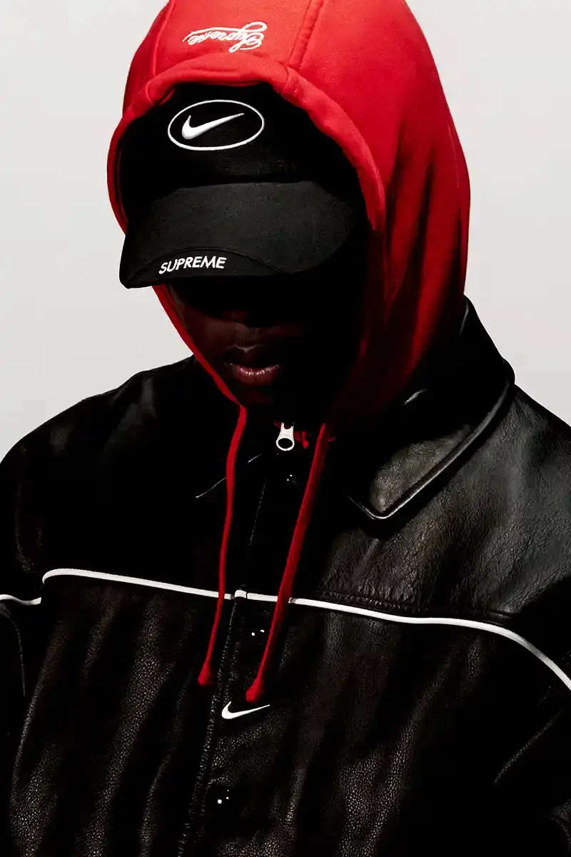 Supreme/Nike Supreme x Nike Spring 2025 Collection featuring black and white Leather Varsity Jackets, purple, yellow and black Track Suits, striped Rugby shirts, Sweater Vests, Hooded Sweatshirts, and accessories including Running Hats and Leather Shoulder Bags. (image 3 of 22)