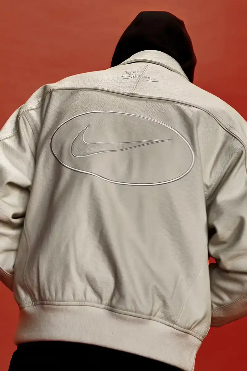 Supreme/Nike Supreme x Nike Spring 2025 Collection featuring black and white Leather Varsity Jackets, purple, yellow and black Track Suits, striped Rugby shirts, Sweater Vests, Hooded Sweatshirts, and accessories including Running Hats and Leather Shoulder Bags. (image 22 of 22)