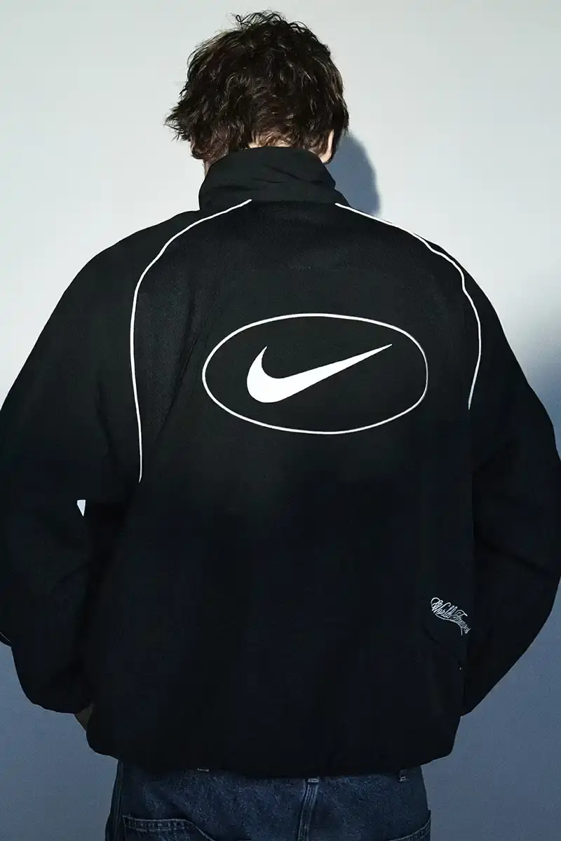 Supreme/Nike Supreme x Nike Spring 2025 Collection featuring black and white Leather Varsity Jackets, purple, yellow and black Track Suits, striped Rugby shirts, Sweater Vests, Hooded Sweatshirts, and accessories including Running Hats and Leather Shoulder Bags. (image 17 of 22)