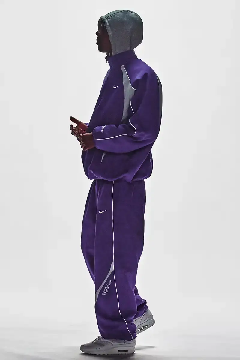 Supreme/Nike Supreme x Nike Spring 2025 Collection featuring black and white Leather Varsity Jackets, purple, yellow and black Track Suits, striped Rugby shirts, Sweater Vests, Hooded Sweatshirts, and accessories including Running Hats and Leather Shoulder Bags. (image 20 of 22)