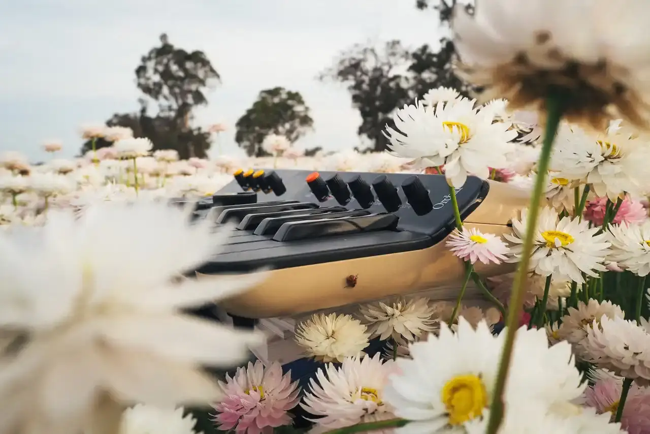 Telepathic Instruments Image of The Orchid, a portable digital synthesizer with a sleek design, featuring multiple control buttons and a keyboard interface. Created by Tame Impala's Kevin Parker through Telepathic Instruments. (image 5 of 6)