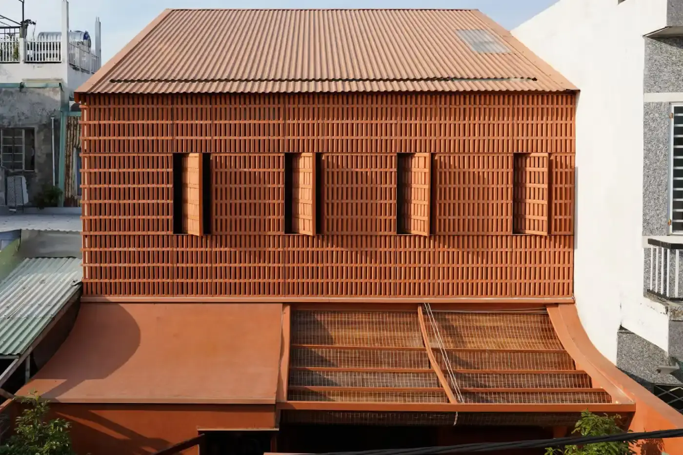 TERRACOTTA BRICK HOUSE IN VIETNAM BALANCES VENTILATION & PRIVACY Live Out Studio, A residential house in Da Nang, Vietnam features perforated terracotta brick walls and internal courtyards to provide ventilation and natural light in a narrow urban lot.