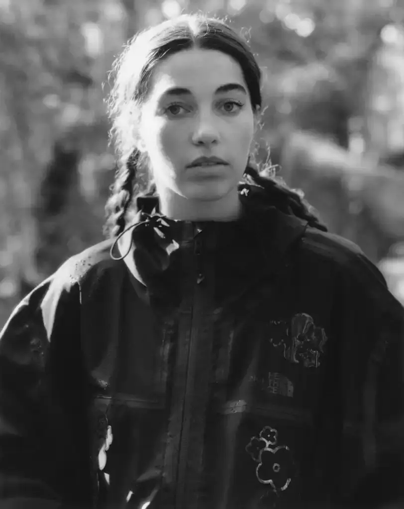 Cecile Bahnsen Models wearing The North Face x Cecile Bahnsen collection climbing on rocks in Fontainebleau natural setting.