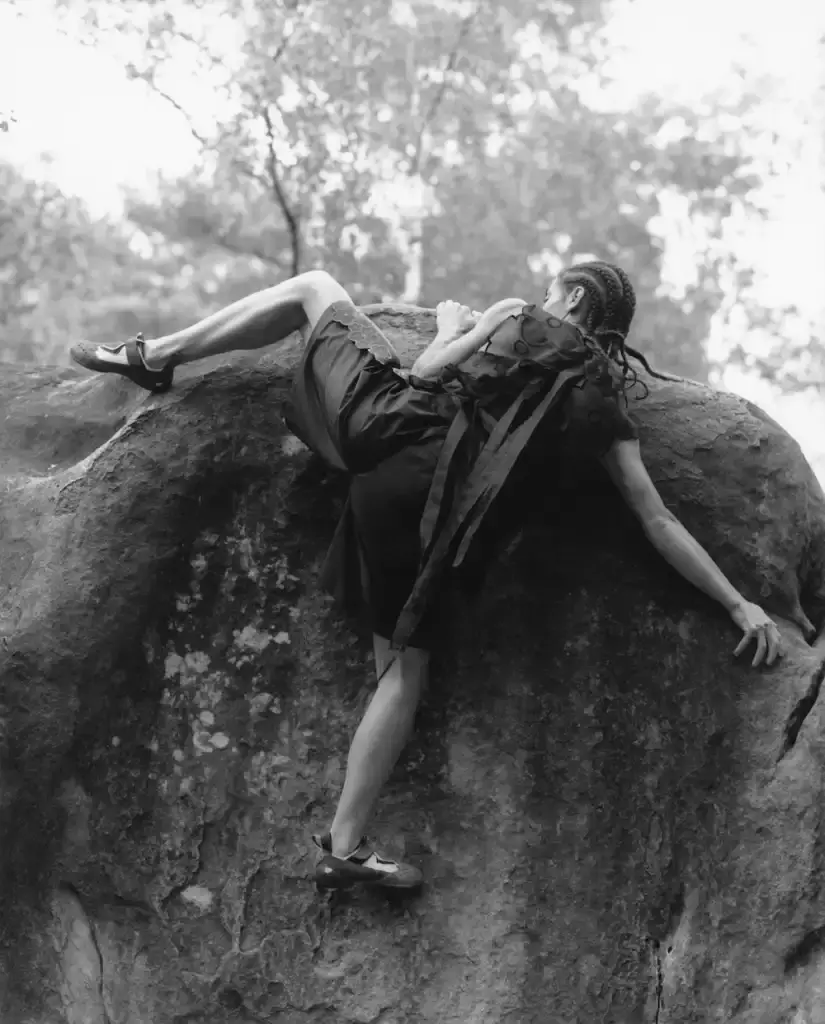 Cecile Bahnsen Models wearing The North Face x Cecile Bahnsen collection climbing on rocks in Fontainebleau natural setting. (image 2 of 6)
