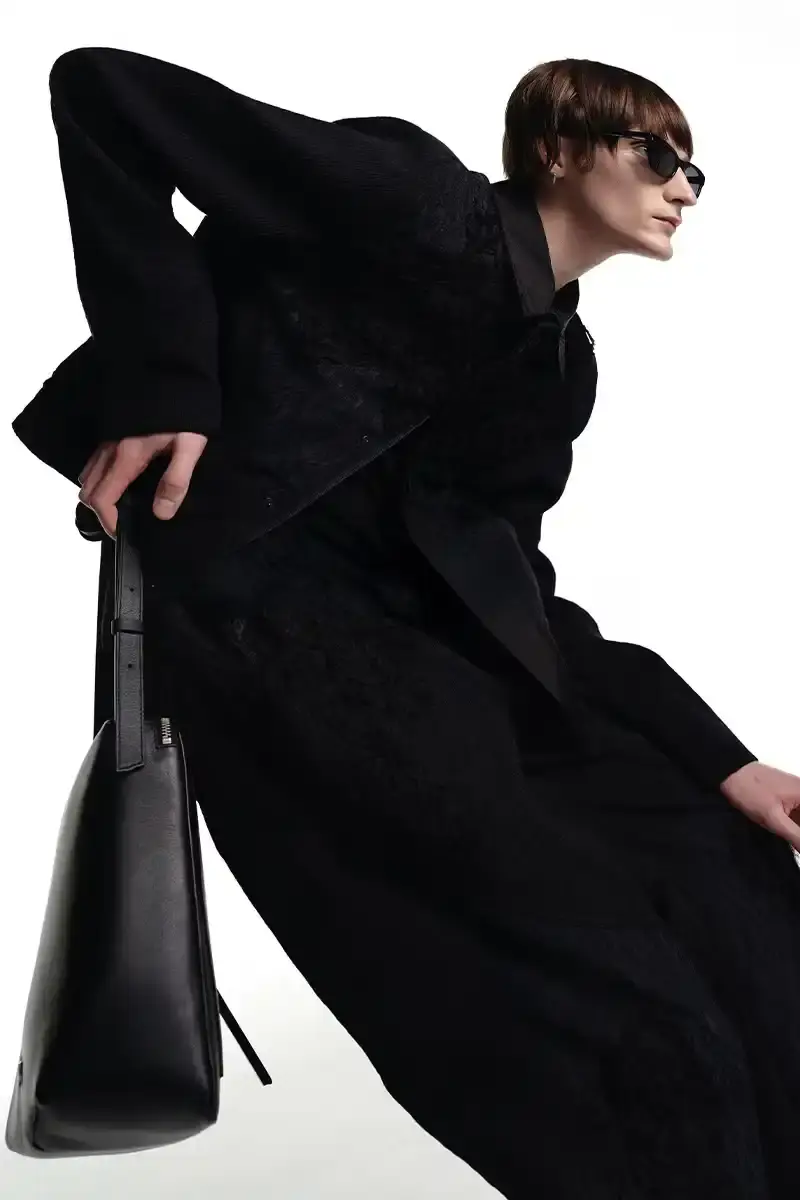 ADER ERROR A fashion collection lookbook featuring minimalist designs that blend architectural silhouettes with subtle, intricate details. Garments in muted tones showcase complex knot work, layered textures, and geometric patterns that explore themes of memory and connection. Models wear carefully constructed outerwear, skirt sets, and tops that challenge traditional fashion boundaries. (image 2 of 3)