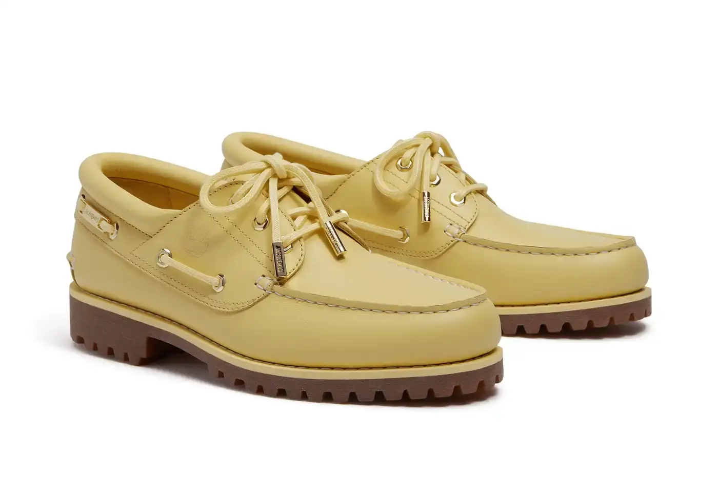 TIMBERLAND X JACQUEMUS COLLABORATION TRANSFORMS CLASSIC BOAT SHOE pictures of "La Bateau," a collaborative shoe between Timberland and Jacquemus. The design refreshes Timberland's classic 3-Eye Lug Boat Shoe with a bright yellow color and gold metal accents, including unique lace eyelets. The premium leather shoe will be available at Jacquemus stores, Timberland's Tokyo flagship, and online for £225 GBP ($250 USD). (image 4 of 5)