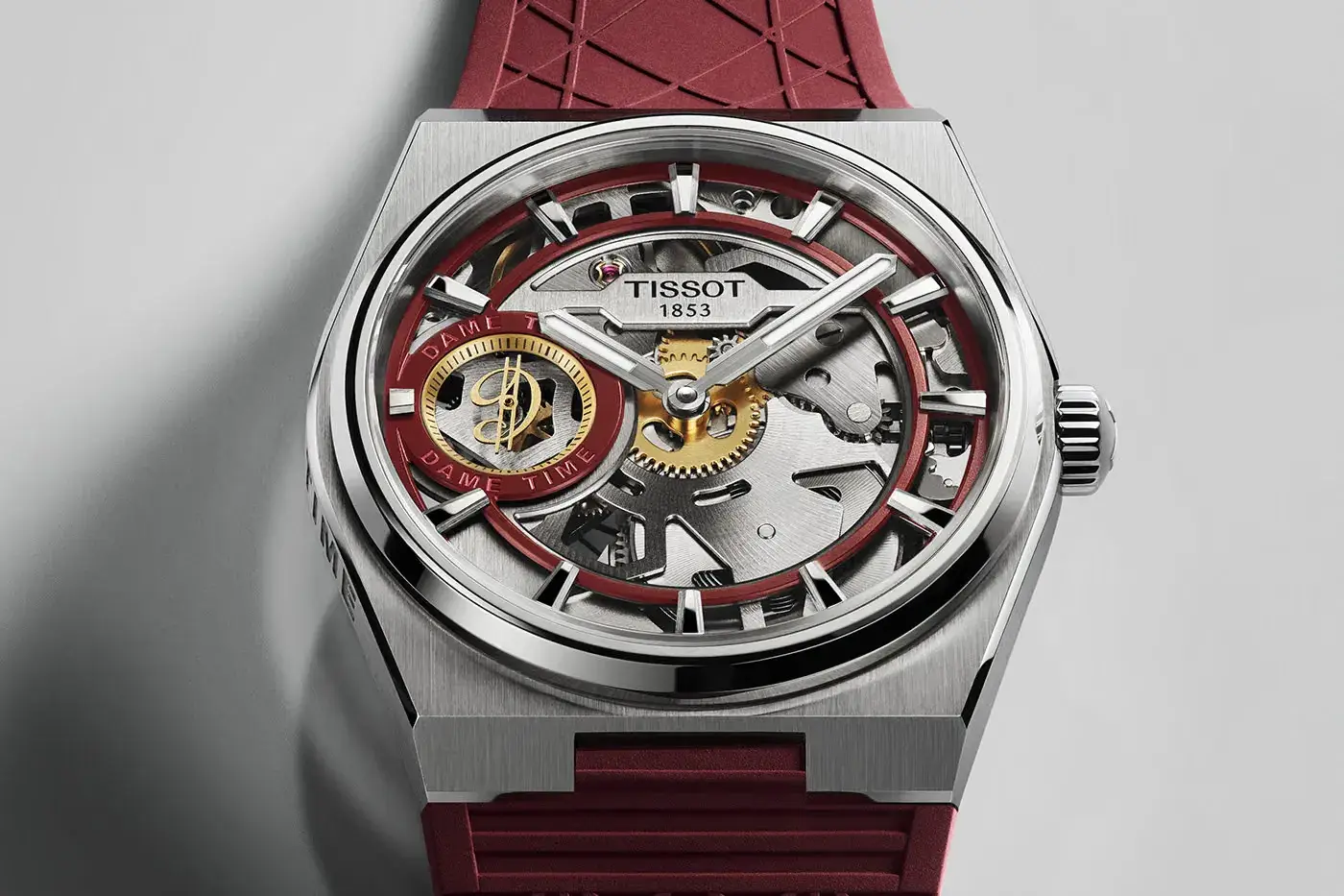 TISSOT RELEASES THE PRX SKELETON DAMIAN LILLARD EDITION Tissot PRX Skeleton Damian Lillard Special Edition, a 44mm steel watch with an openworked dial, burgundy straps and a gold-colored seconds hand. (image 3 of 7)