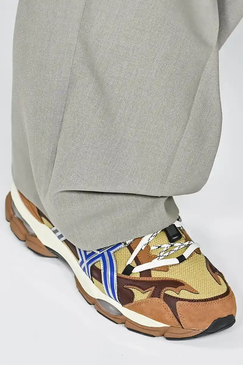 Victor Virgile/Gamma-Rapho/Getty Images TOGA x ASICS collaborative sneakers featuring decorative appliqué, dual lacing system, and ornamental hardware in gray, silver/red, and earth tone colorways. (image 2 of 5)