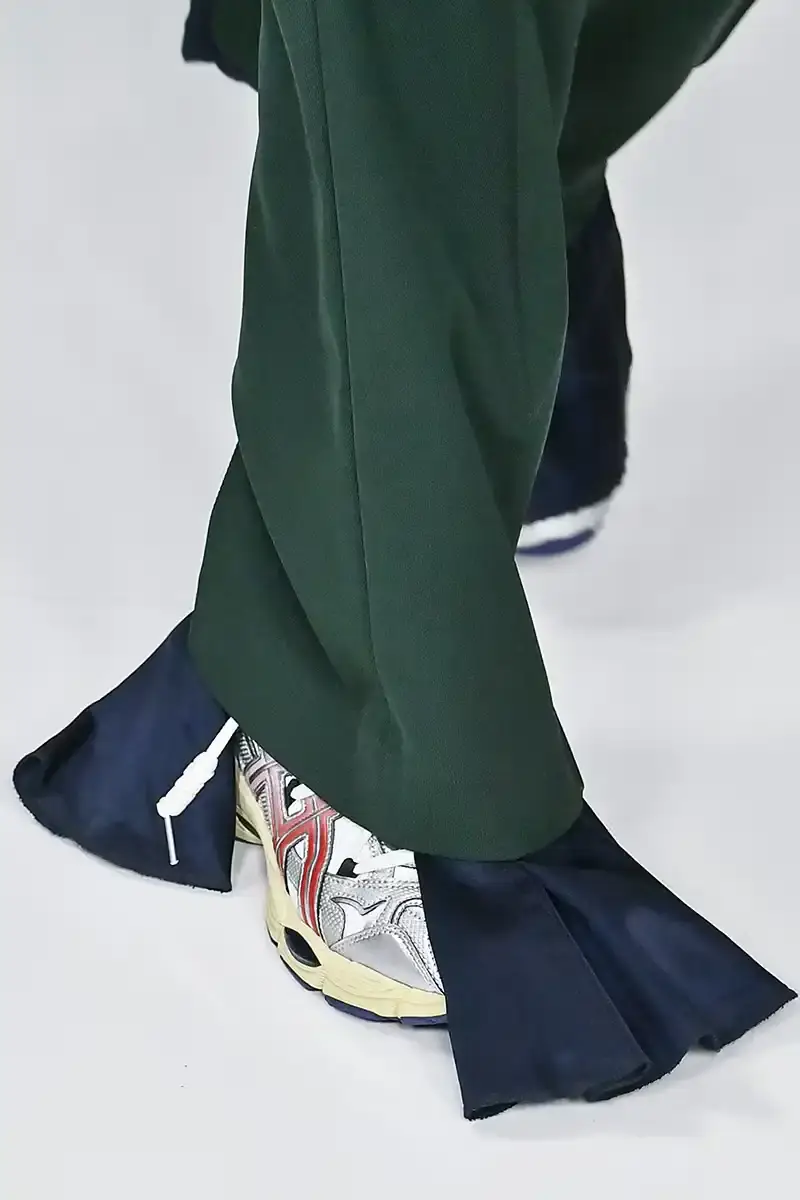 Victor Virgile/Gamma-Rapho/Getty Images TOGA x ASICS collaborative sneakers featuring decorative appliqué, dual lacing system, and ornamental hardware in gray, silver/red, and earth tone colorways. (image 4 of 5)