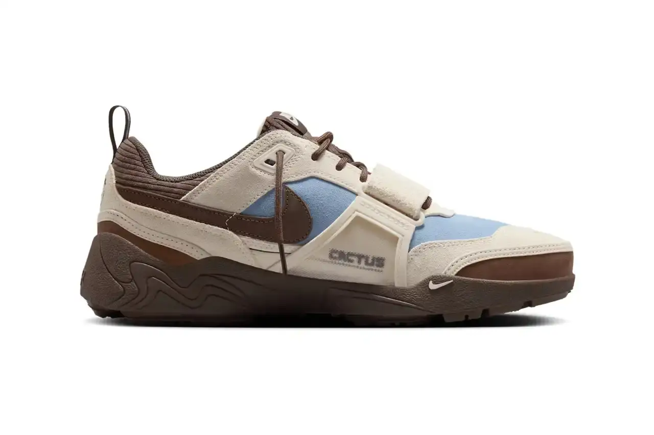 NIKE UNVEILS TRAVIS SCOTT'S ZOOM FIELD JAXX IN "LECHE BLUE" Image of the upcoming release of the Travis Scott x Nike Zoom Field Jaxx sneaker in "Leche Blue" colorway. It details the shoe's design inspiration from the Zoom Spiridon runner and Land Shark baseball cleat, describes the blue and brown color scheme, mentions the $170 price point, and notes the May 16 release date through Nike SNKRS and select retailers. (image 2 of 7)
