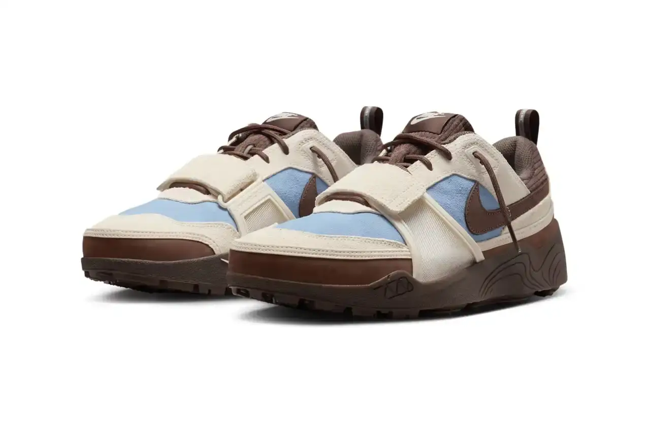 NIKE UNVEILS TRAVIS SCOTT'S ZOOM FIELD JAXX IN "LECHE BLUE" Image of the upcoming release of the Travis Scott x Nike Zoom Field Jaxx sneaker in "Leche Blue" colorway. It details the shoe's design inspiration from the Zoom Spiridon runner and Land Shark baseball cleat, describes the blue and brown color scheme, mentions the $170 price point, and notes the May 16 release date through Nike SNKRS and select retailers. (image 3 of 7)