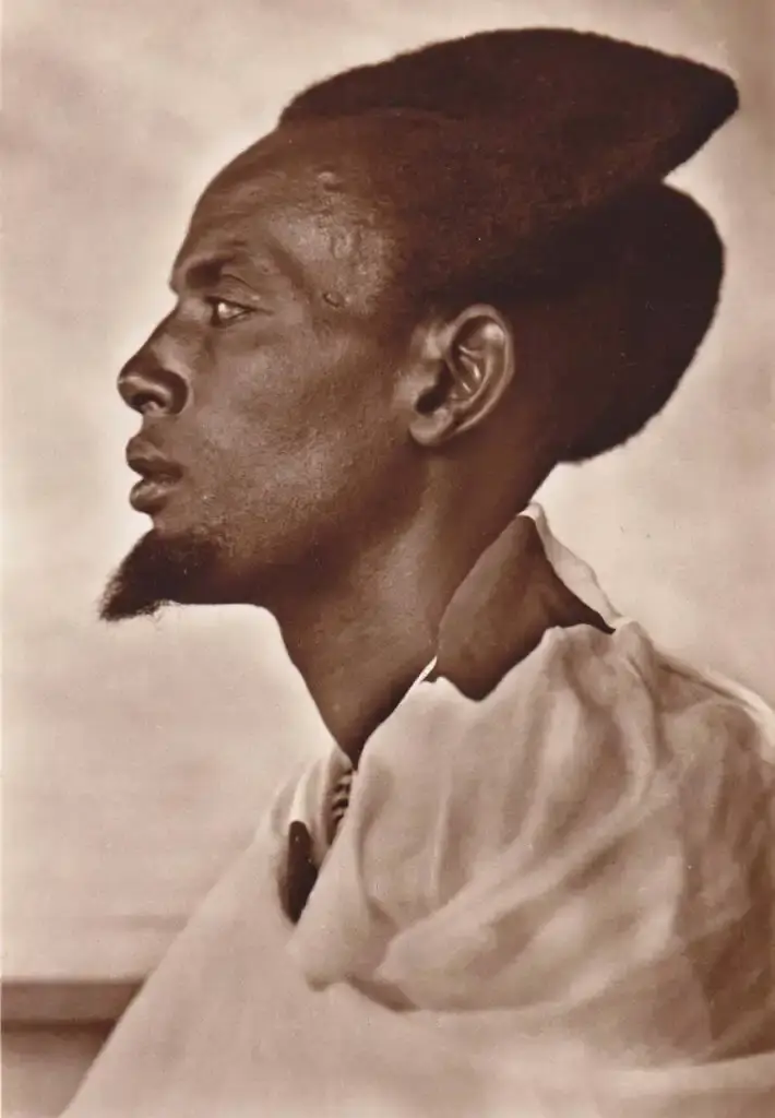 Traditional Rwandan Amasunzu hairstyle showing intricate crescent-shaped patterns and precise geometric shaving. (image 5 of 6)