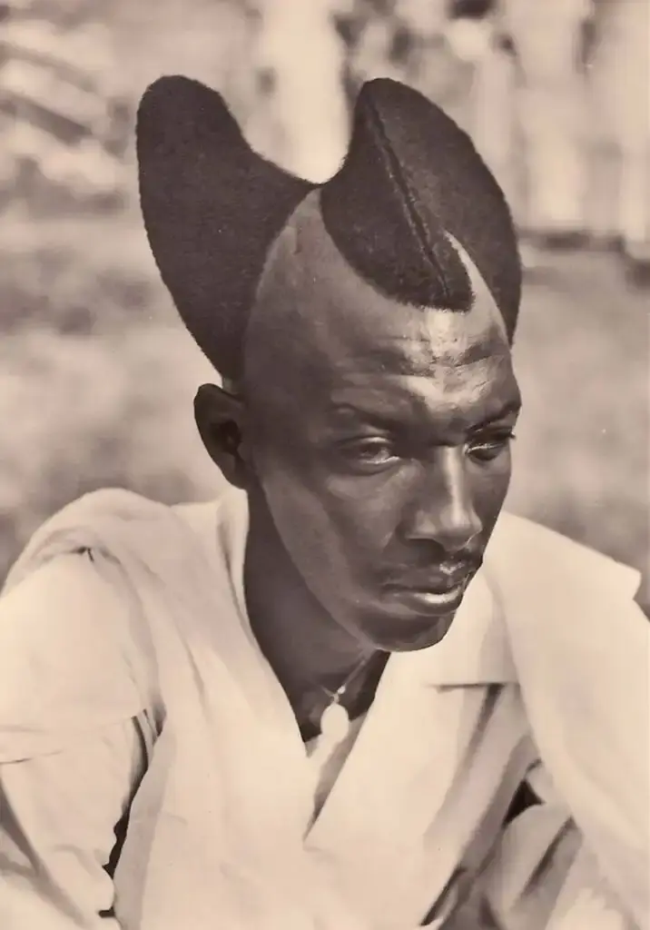 Traditional Rwandan Amasunzu hairstyle showing intricate crescent-shaped patterns and precise geometric shaving.