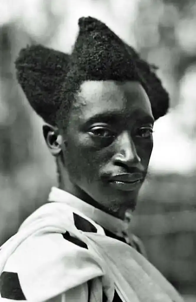 Traditional Rwandan Amasunzu hairstyle showing intricate crescent-shaped patterns and precise geometric shaving. (image 4 of 6)