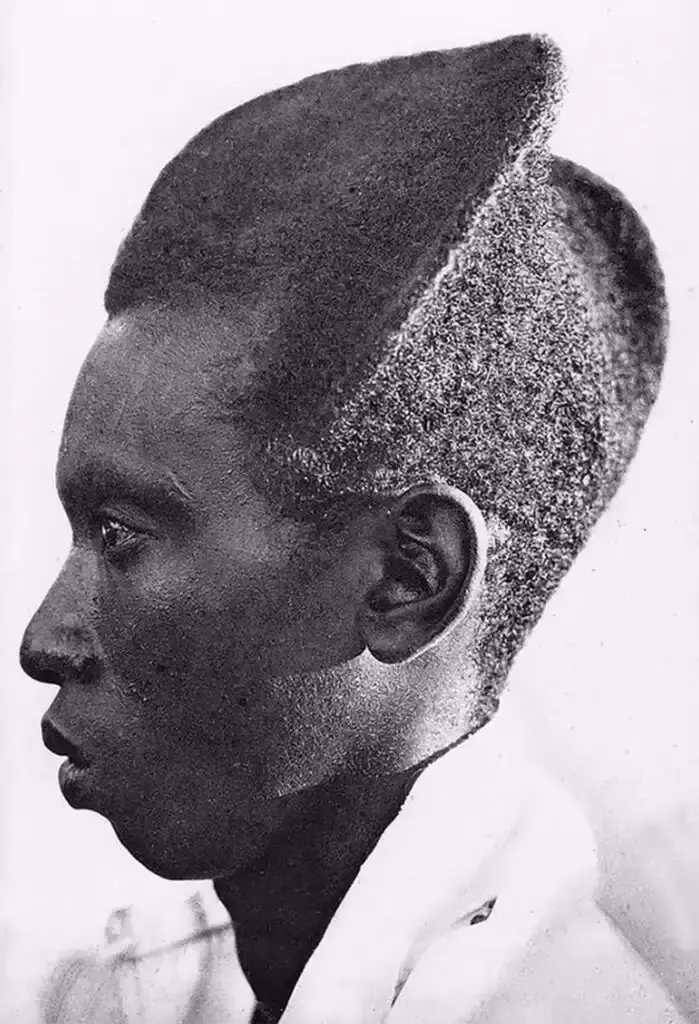 Traditional Rwandan Amasunzu hairstyle showing intricate crescent-shaped patterns and precise geometric shaving. (image 6 of 6)