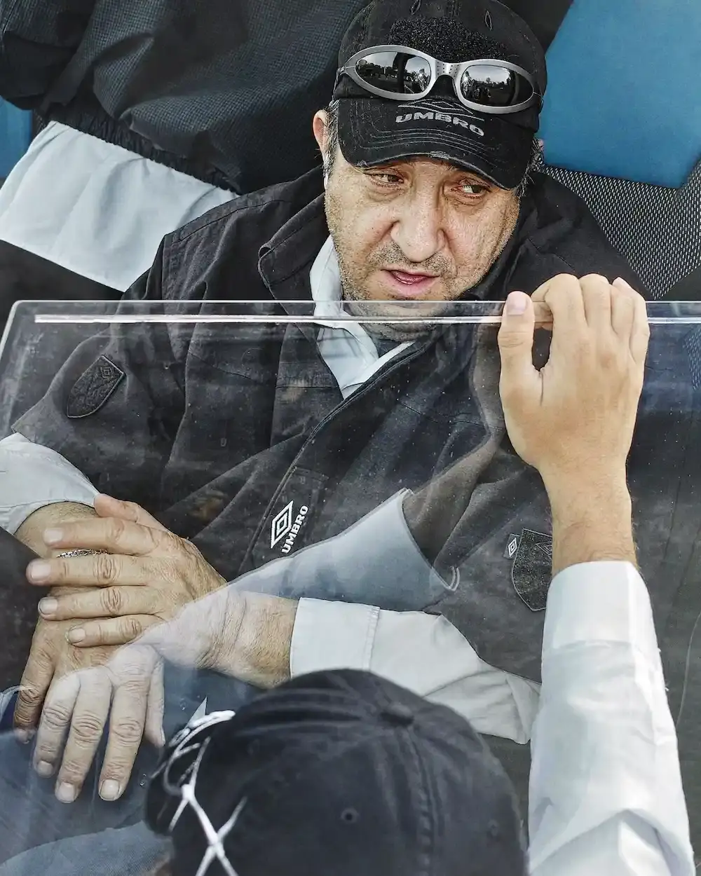Umbro/Slam Jam Campaign image for Umbro by Slam Jam Spring/Summer 2025 collection, photographed by Satoshi Fujiwara. Models wearing security-inspired sportswear inside a bus, capturing the atmosphere of football away trips.