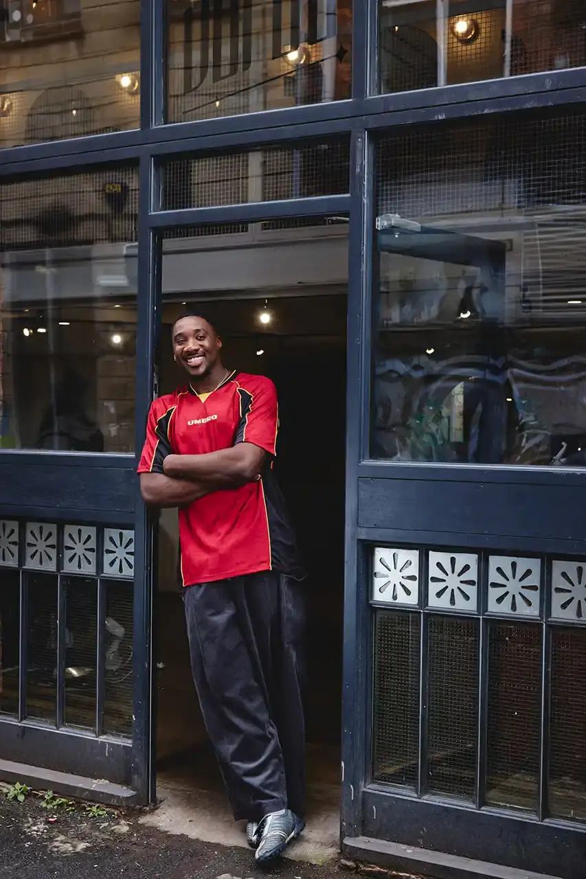Umbro Umbro SS25 Northern Quarter collection featuring redesigned sportswear classics in white, red, black and charcoal gray, including the Zip Off Sleeve Wind Jacket and '90s-inspired Washed Drill pieces that blend Manchester heritage with contemporary design. (image 14 of 15)
