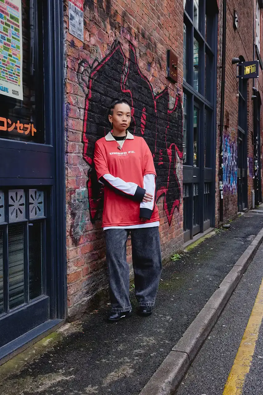 Umbro Umbro SS25 Northern Quarter collection featuring redesigned sportswear classics in white, red, black and charcoal gray, including the Zip Off Sleeve Wind Jacket and '90s-inspired Washed Drill pieces that blend Manchester heritage with contemporary design. (image 13 of 15)