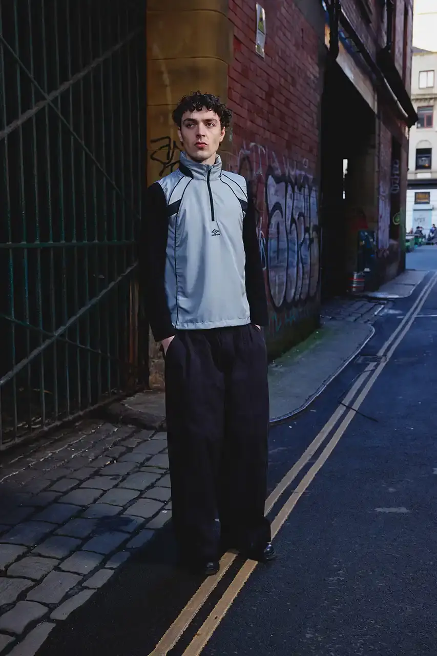 Umbro Umbro SS25 Northern Quarter collection featuring redesigned sportswear classics in white, red, black and charcoal gray, including the Zip Off Sleeve Wind Jacket and '90s-inspired Washed Drill pieces that blend Manchester heritage with contemporary design. (image 8 of 15)