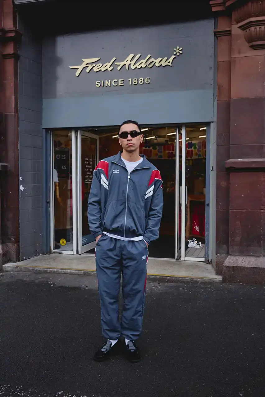 Umbro Umbro SS25 Northern Quarter collection featuring redesigned sportswear classics in white, red, black and charcoal gray, including the Zip Off Sleeve Wind Jacket and '90s-inspired Washed Drill pieces that blend Manchester heritage with contemporary design. (image 5 of 15)