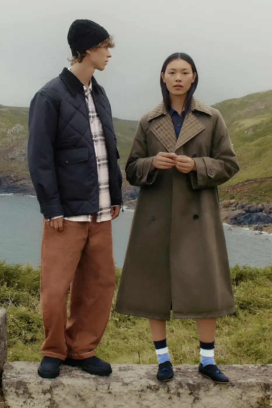 UNIQLO x JW Anderson Fall Winter 2024 collection display featuring coastal-inspired outerwear and knitwear against a minimalist background