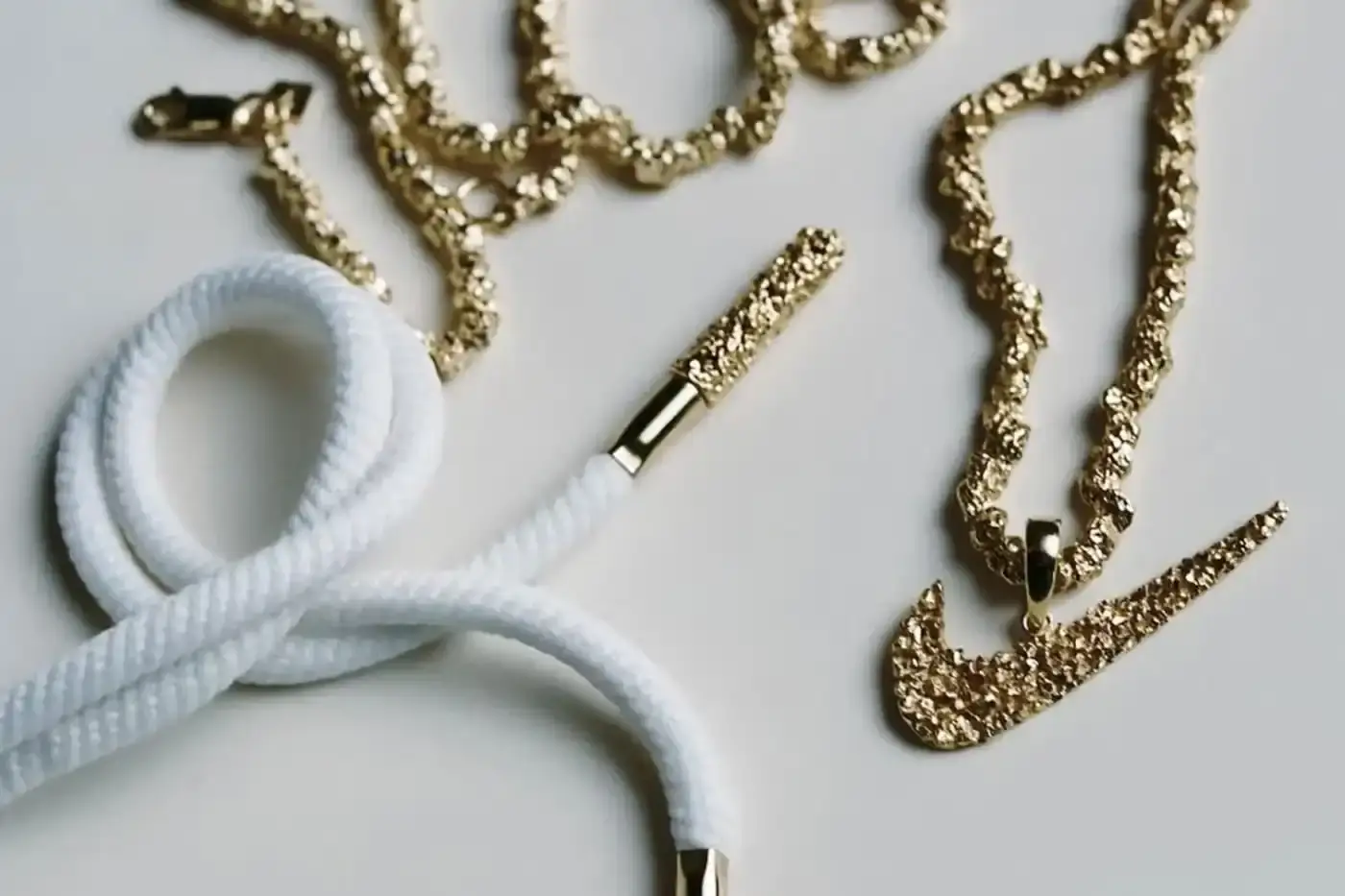 image of the upcoming collaboration between celebrity stylist Veneda Carter and Nike, featuring two Air Max Muse sneaker colorways scheduled for Fall 2025 release. The article describes the social media teaser posted by Carter showing gold chain details and white laces with gold eyelets, mentions both colorway specifications (White/Hyper Pink/Cargo Khaki and White/Racer Blue/Bright Crimson), notes the $170 USD price point, and explains how speculation began when Carter was spotted wearing Air Max Craze shoes earlier. The content provides product information for sneaker enthusiasts interested in this limited-edition release.
