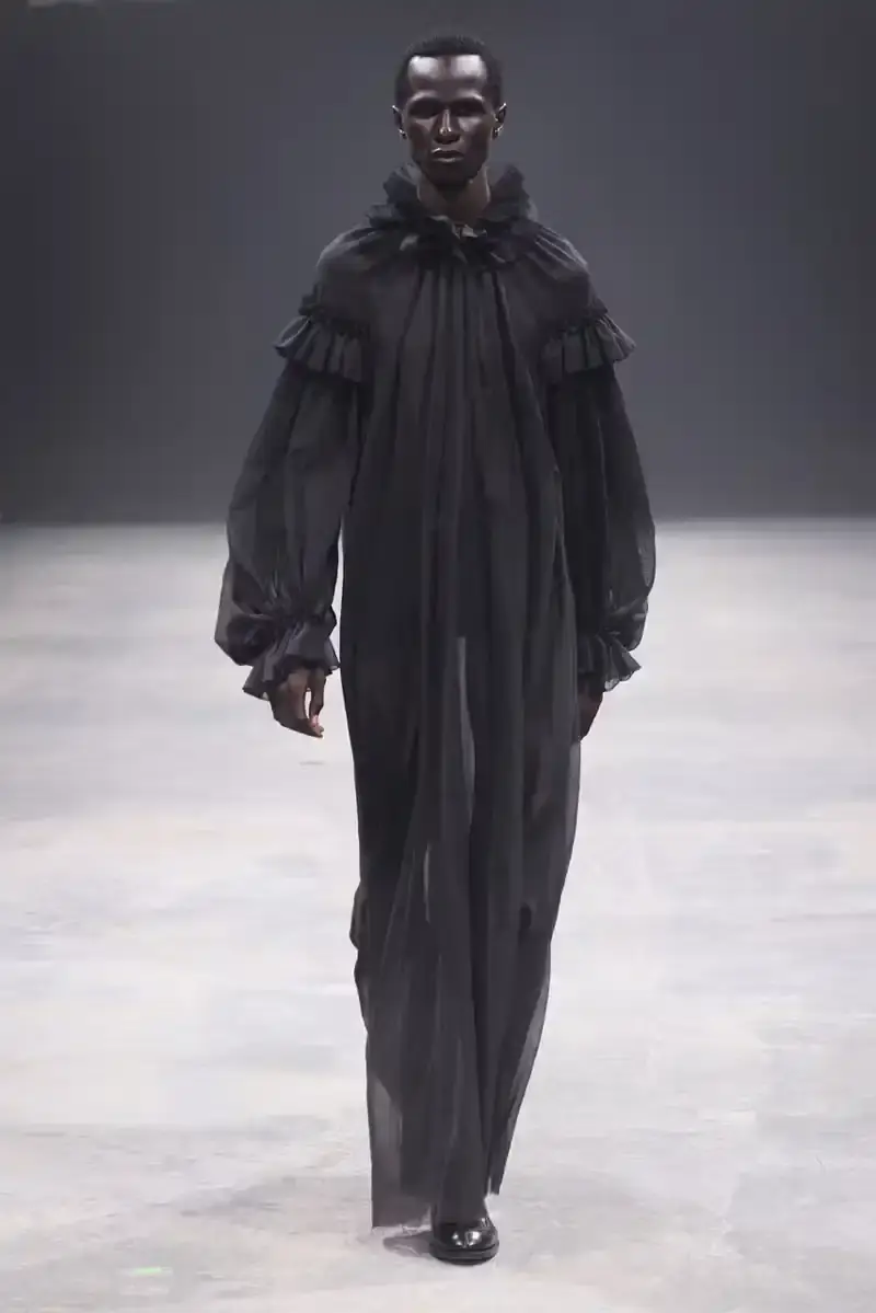 WILLY CHAVARRIA SS25: A SARTORIAL ODE TO THE AMERICAN DREAM Models walk the runway at Willy Chavarria's SS25 'América' show, wearing dramatic workwear-inspired designs against an industrial backdrop (image 10 of 15)