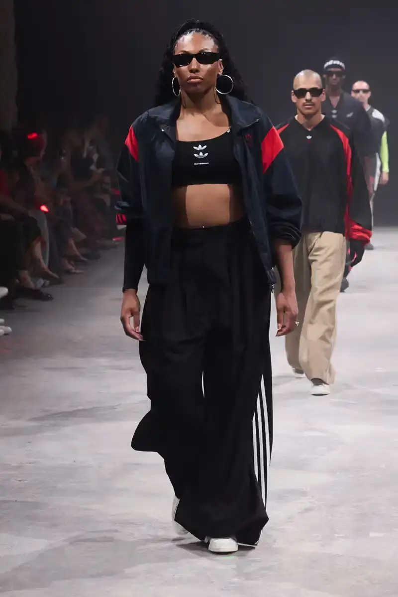 WILLY CHAVARRIA SS25: A SARTORIAL ODE TO THE AMERICAN DREAM Athletic model showcasing Willy Chavarria x adidas collaboration: avant-garde quarter-zip jacket with prominent Three Stripes logo