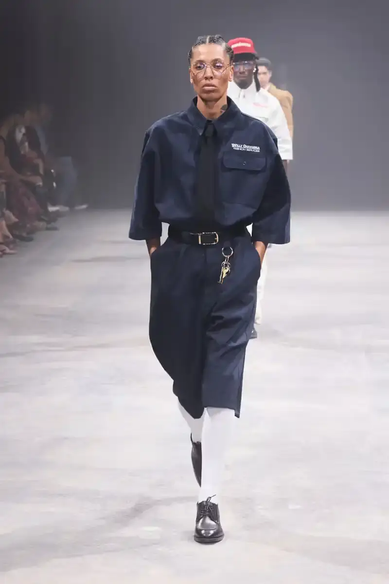 WILLY CHAVARRIA SS25: A SARTORIAL ODE TO THE AMERICAN DREAM Models walk the runway at Willy Chavarria's SS25 'América' show, wearing dramatic workwear-inspired designs against an industrial backdrop (image 3 of 15)